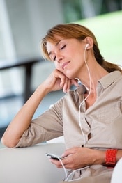 portrait de femme qui coute de la musique avec des oreillettes